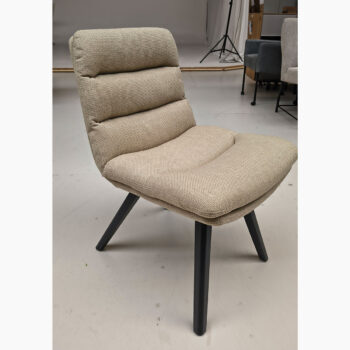 Showroommodel van luxe eetkamerstoel bij Houweling Interieur. Moderne eetkamerstoel uitgevoerd in beige stof en zwarte poten.