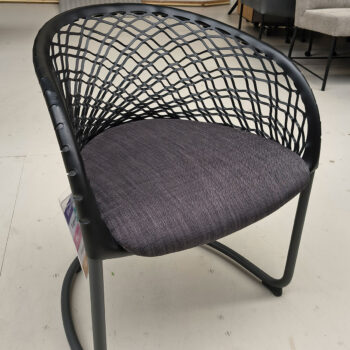 Showroommodel van design eetkamerstoel bij Houweling Interieur. Moderne eetkamerstoel met leren leuning en grijs kussen.