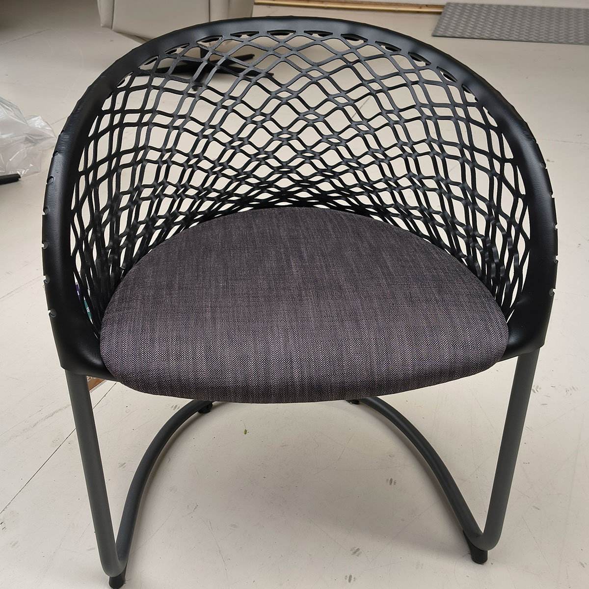 Showroommodel van design eetkamerstoel bij Houweling Interieur. Moderne eetkamerstoel met leren leuning en grijs kussen.