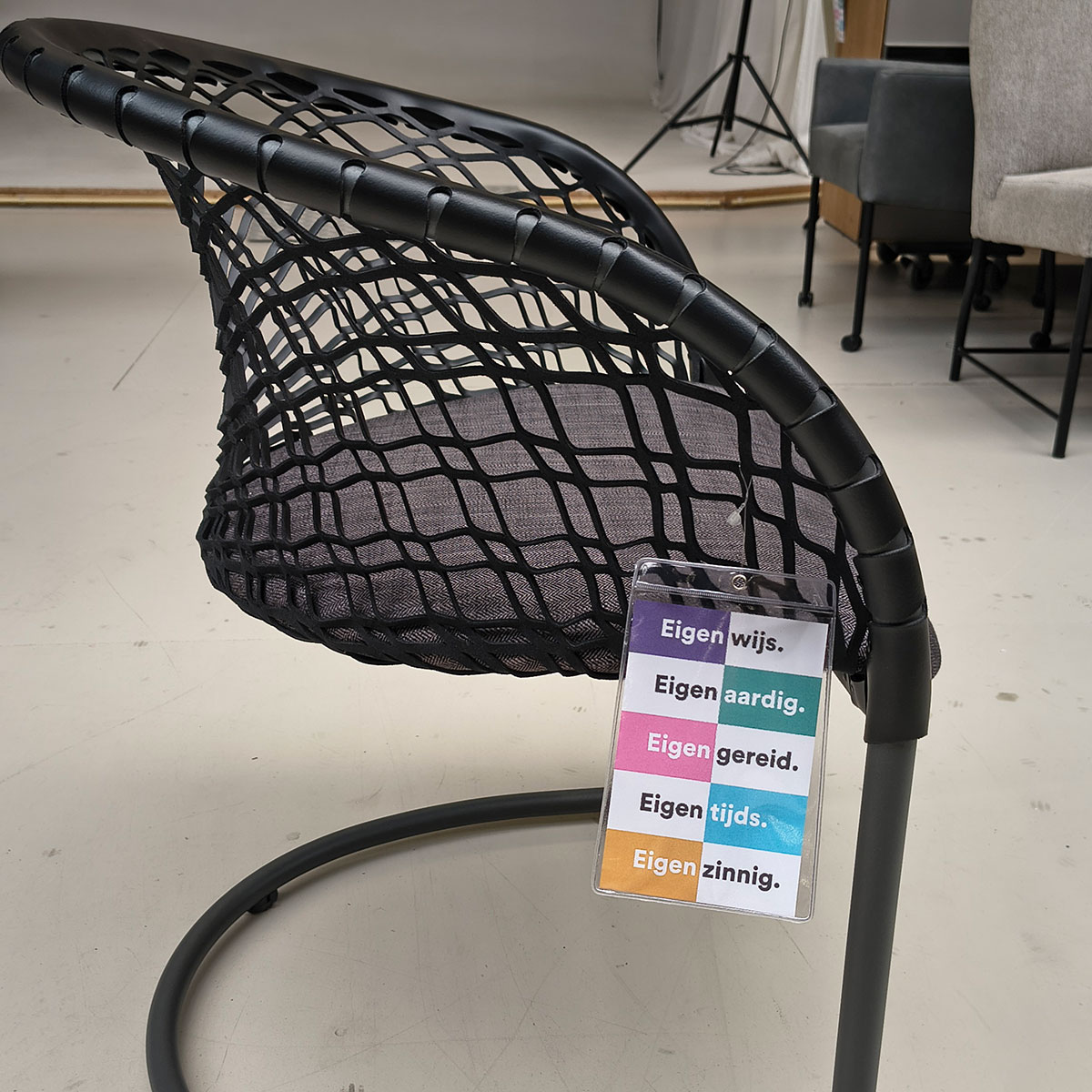 Showroommodel van design eetkamerstoel bij Houweling Interieur. Moderne eetkamerstoel met leren leuning en grijs kussen.