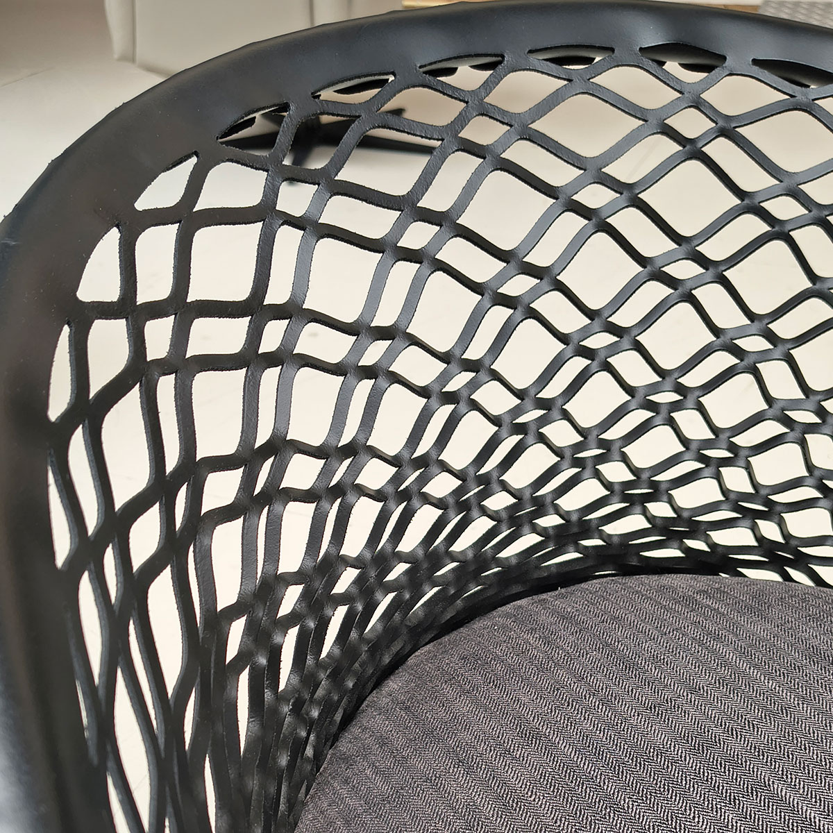 Showroommodel van design eetkamerstoel bij Houweling Interieur. Moderne eetkamerstoel met leren leuning en grijs kussen.