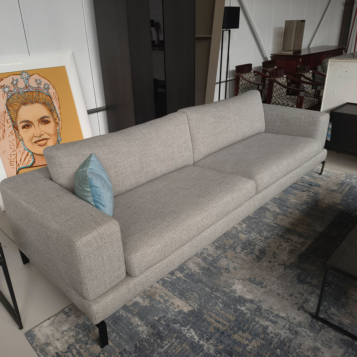 Showroommodel van een 4-zitsbank bij Houweling Interieur. Moderne bank uitgevoerd in lichtgrijze stof en zwarte ranke poten.