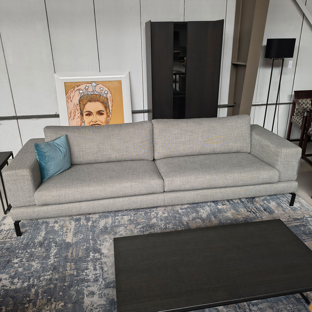 Showroommodel van een 4-zitsbank bij Houweling Interieur. Moderne bank uitgevoerd in lichtgrijze stof en zwarte ranke poten.