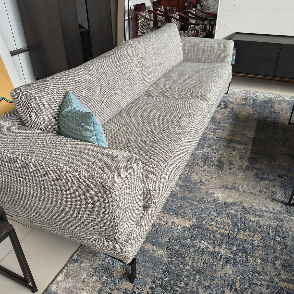 Showroommodel van een 4-zitsbank bij Houweling Interieur. Moderne bank uitgevoerd in lichtgrijze stof en zwarte ranke poten.
