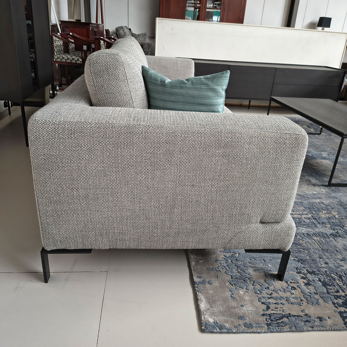 Showroommodel van een 4-zitsbank bij Houweling Interieur. Moderne bank uitgevoerd in lichtgrijze stof en zwarte ranke poten.